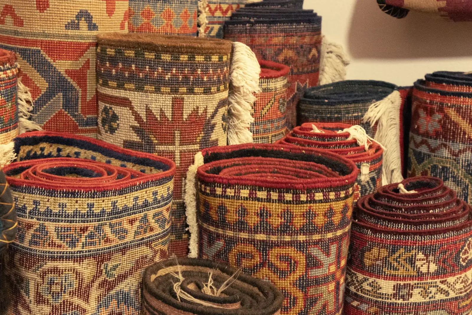 Tapis persan posé à plat sur l'aire de lavage de l'atelier, brosse à long manche sur le velours